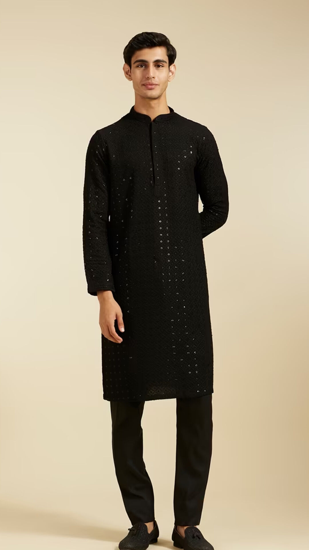 Man wearing a black Chikankari kurta with subtle mirror work and black trousers.